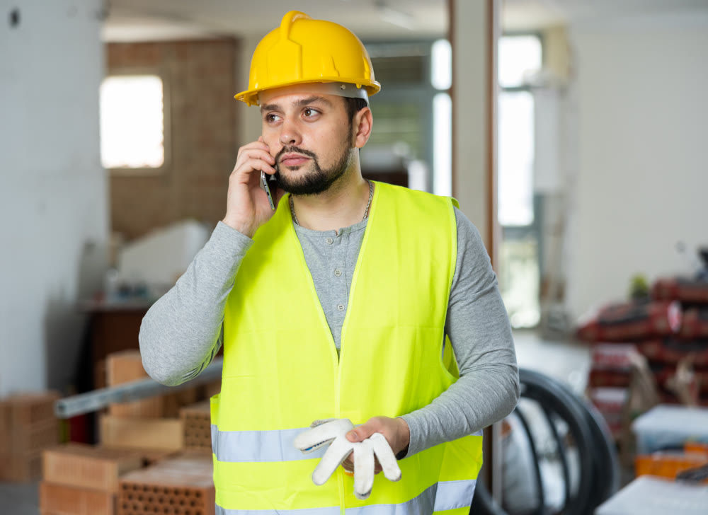 Builder is talking on a mobile phone