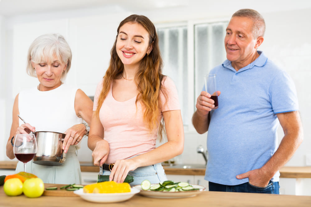 Happy smiling parents enjoy weekend cook with daughter