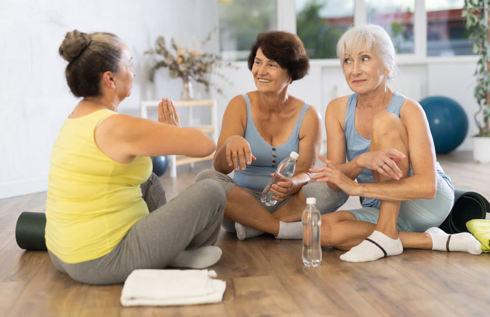 Group of elderly women talking in fitness studio