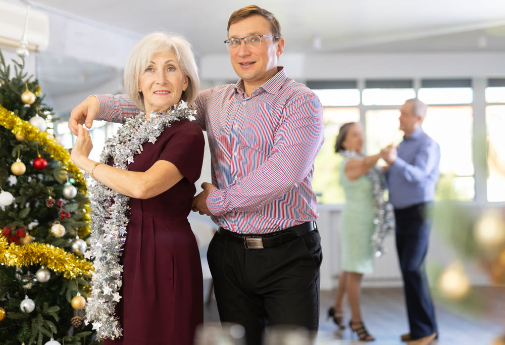 Middle-aged man and elderly woman dancing contemporary discofox in couple in New Year atmosphere