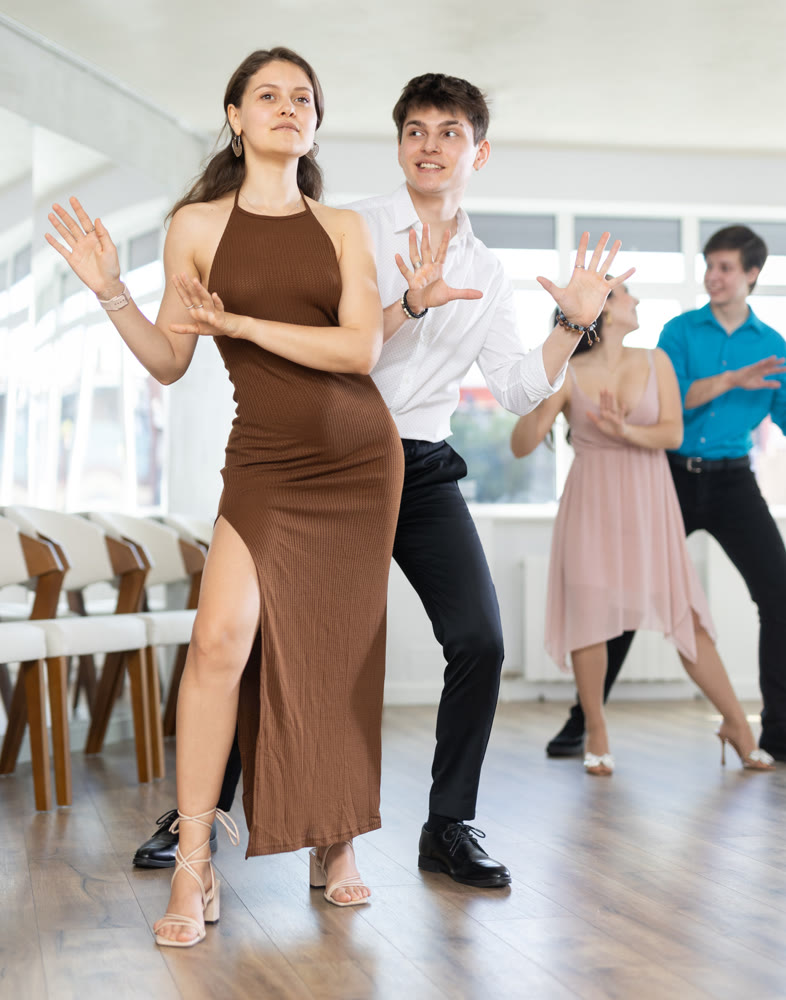 Dancing in a dance studio - couple in festive clothes learning to dance foxtrot