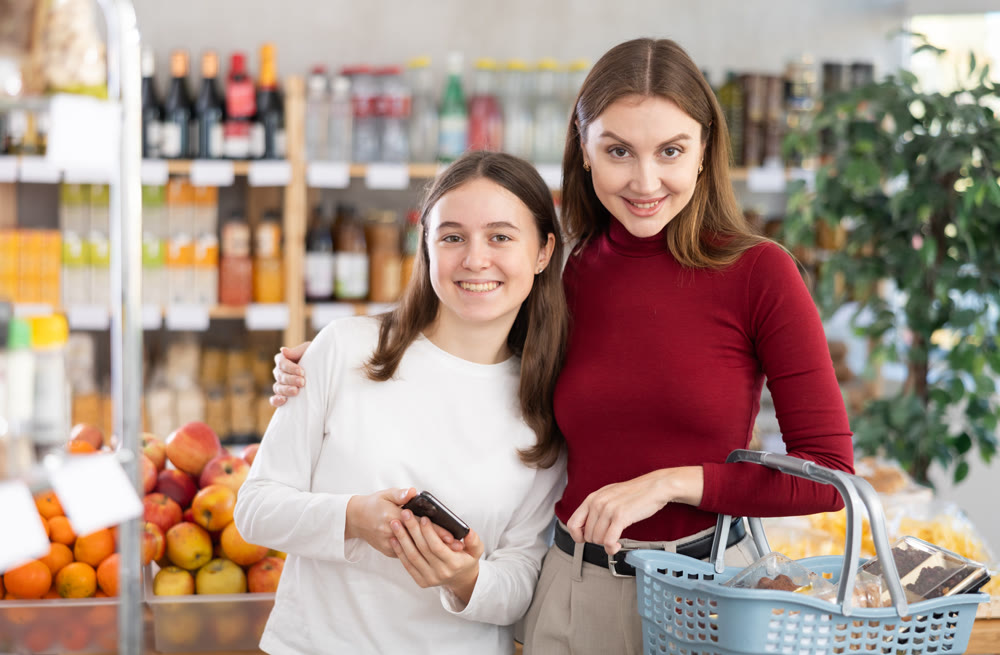 Teenage girl and her mother doing shopping in grocery store