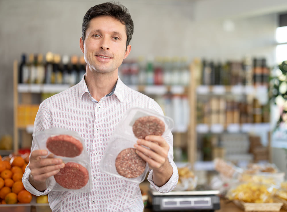 Adult man choosing hamburger in grocery store
