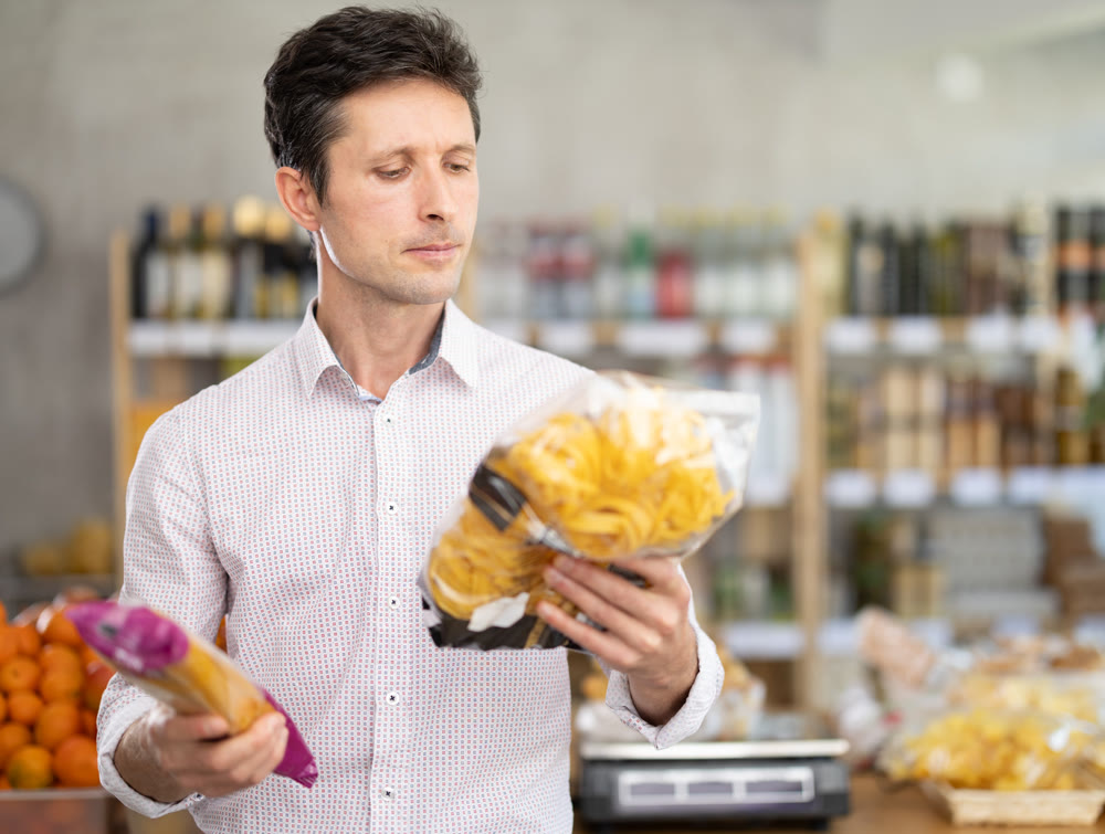 Man choosing pasta in the supermarket