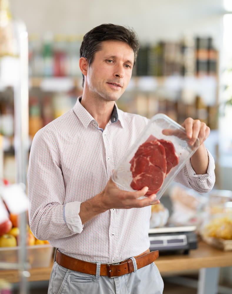 Adult man choosing entrecote in grocery store