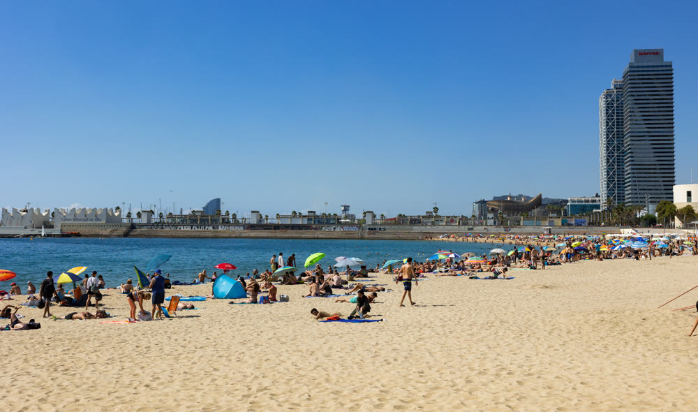 Coastal area of Barcelona with sandy beach and high-rise Mapfre tower and Arts Hotel