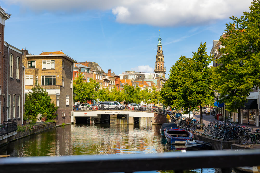 Leiden, Netherlands - August 08, 2022: Traditional houses beside a canal in Leiden - South Holland, Netherlands