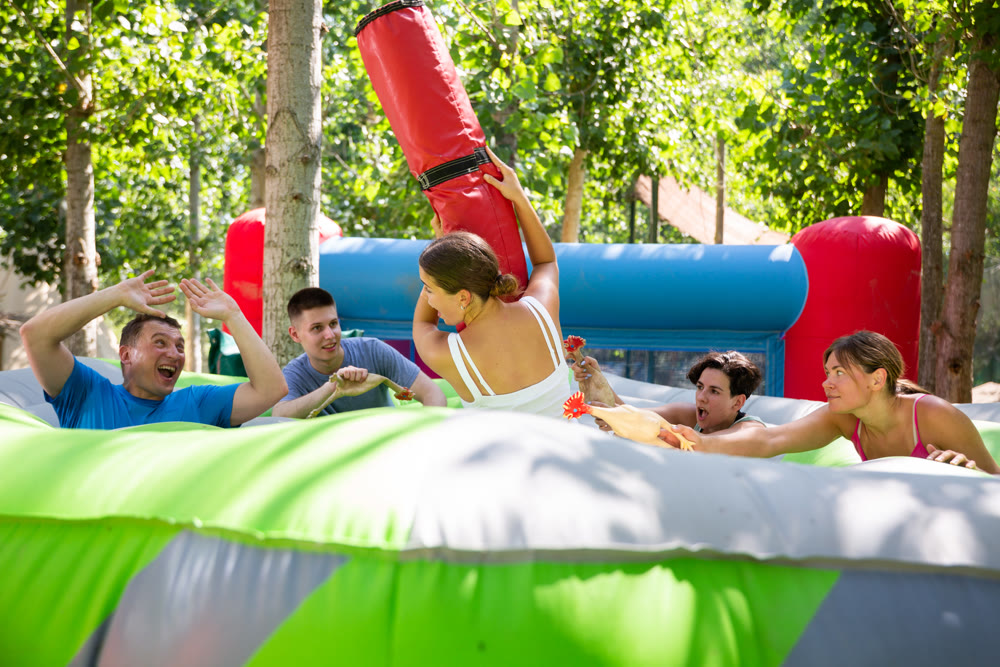 Men and women playing interesting game in adventure park