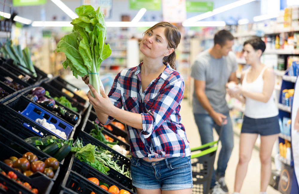 Woman choosing lettuce in supermarket