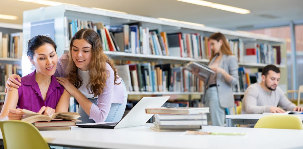 Two female students are preparing for the exam in the library
