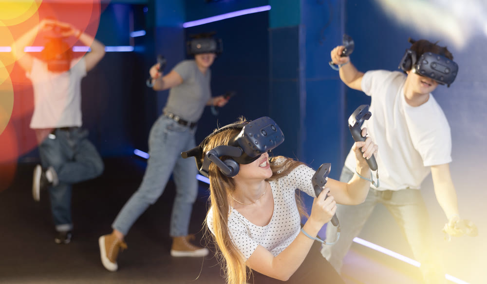 Excited young woman in VR goggles having fun in virtual reality room