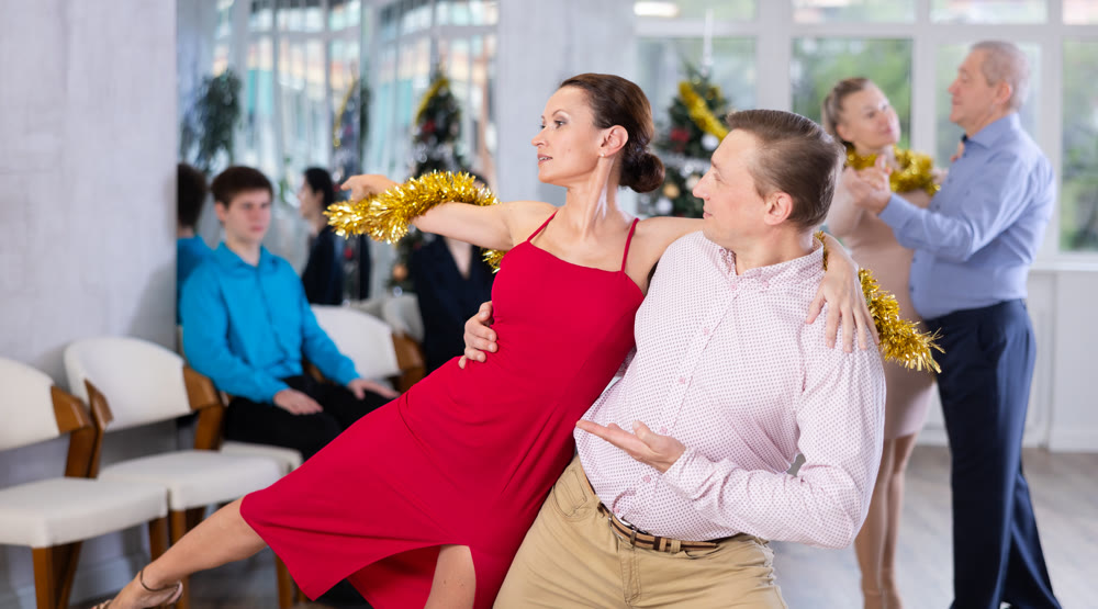 Group of people having fun celebrating Christmas and dancing waltz or tango