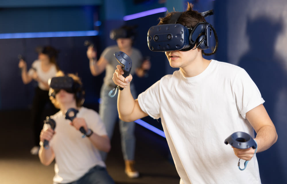 teenager in virtual reality glasses with joystick play survival game in stone jungle of future