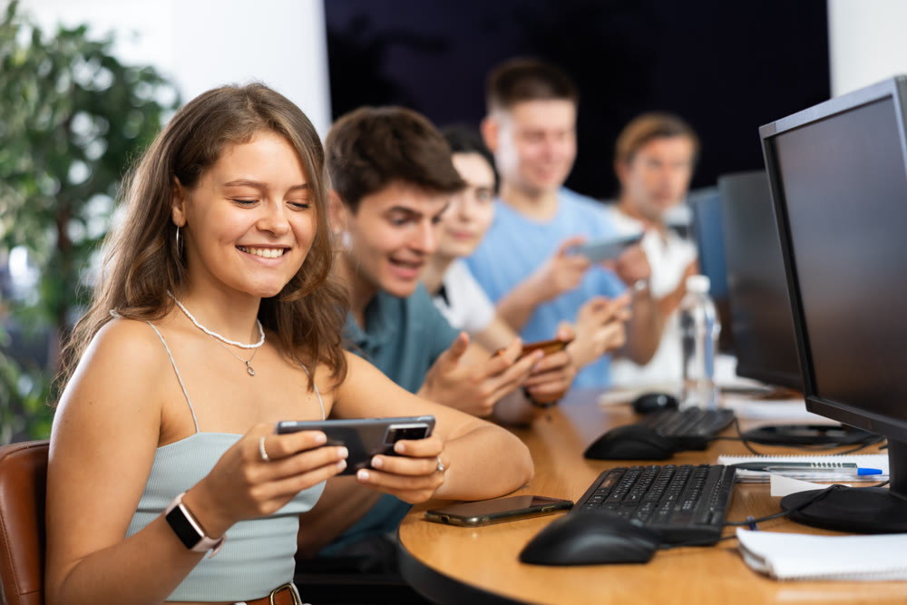 Enthusiastic young girl undergoing training in mobile applications development