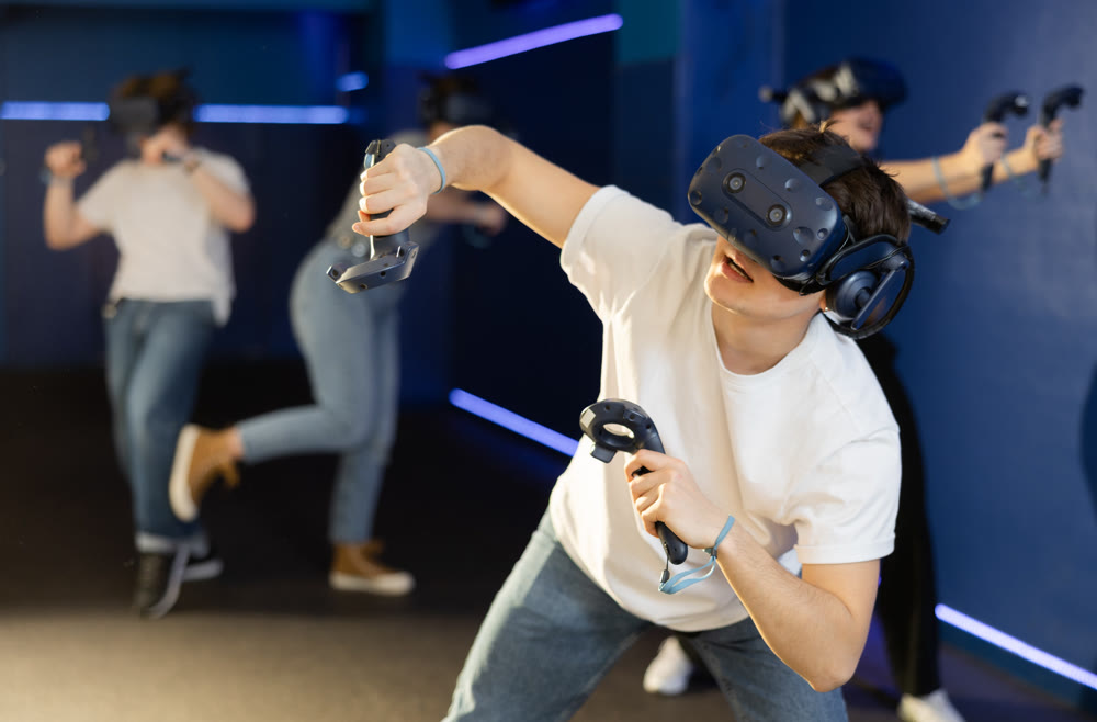teenager in virtual reality glasses with joystick play survival game in stone jungle of future