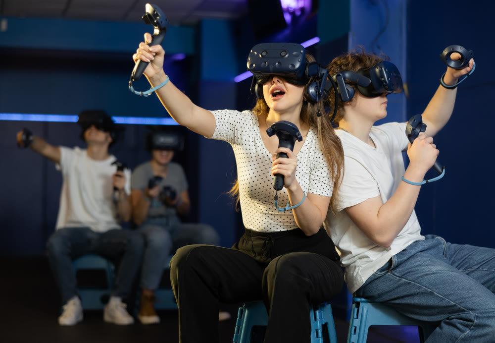 friends in helmets and with joysticks are sitting playing 3d action game. entertainment club