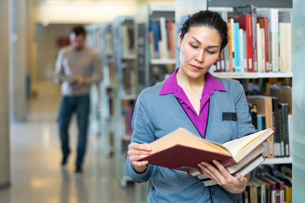 Portrait of woman choosing books at library
