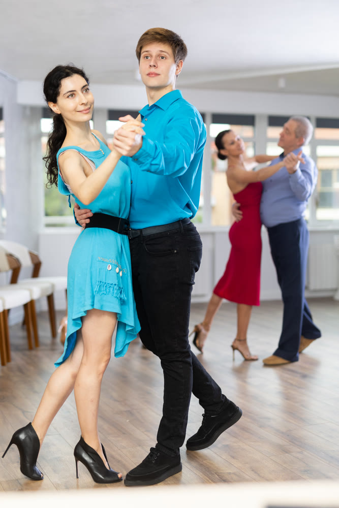Guy and woman dancing slow ballroom dance in choreography studio
