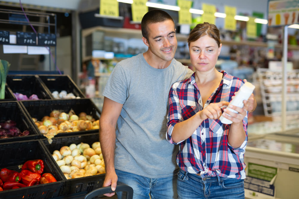Couple selecting shampoo in supermarket
