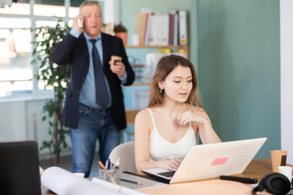 Two manager work on laptops in modern company office