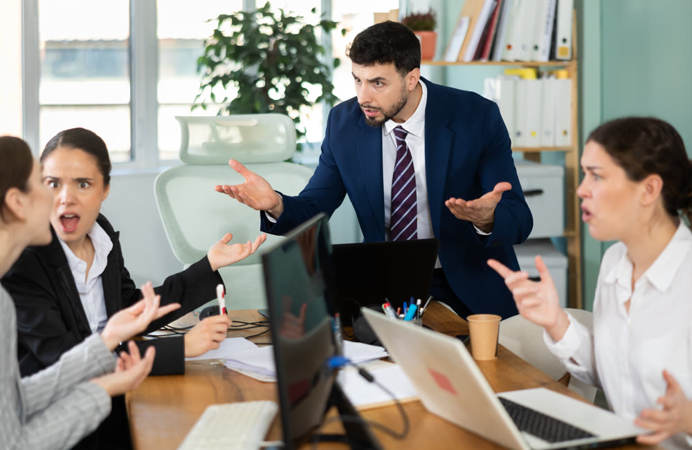 Group of men and women arguing loudly in office