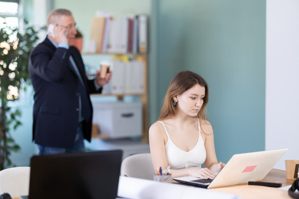 Two manager work on laptops in modern company office