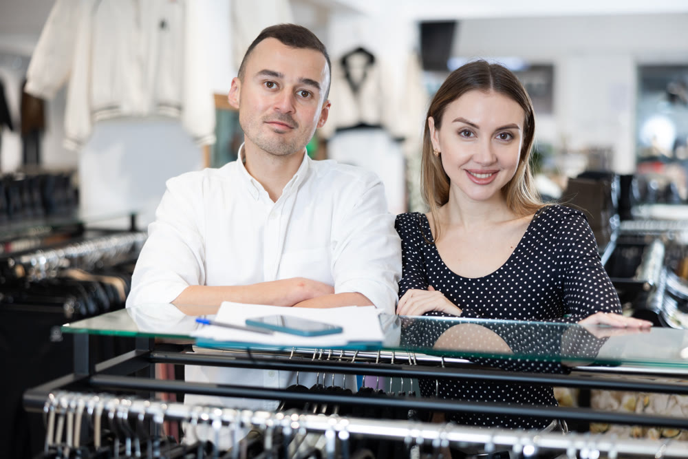 Couple man and woman posing in clothing store
