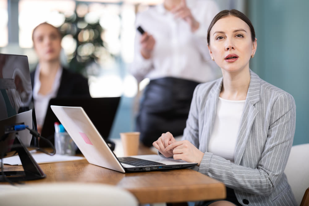 Young woman watching project presentation in modern office