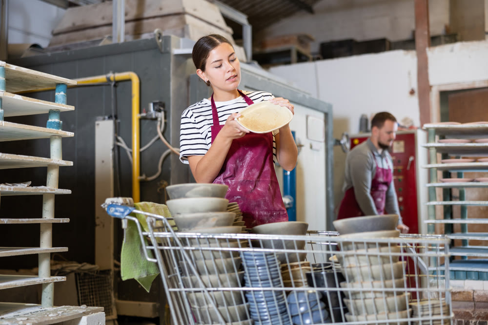 Young woman posing with ceramic dishes