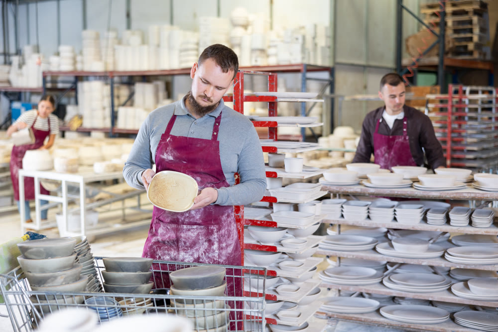 Pottery expert inspecting handmade plate in artisanal ceramics studio