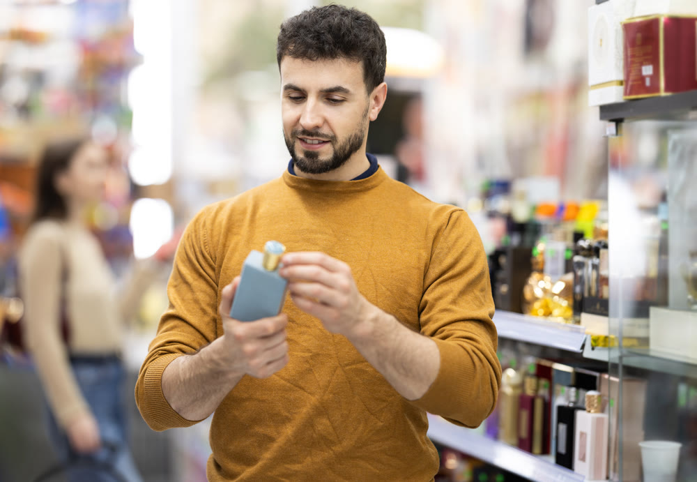 Man shops in mega market and search perfume goods