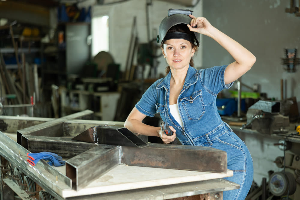 During manufacture of product, woman employee works with welding machine