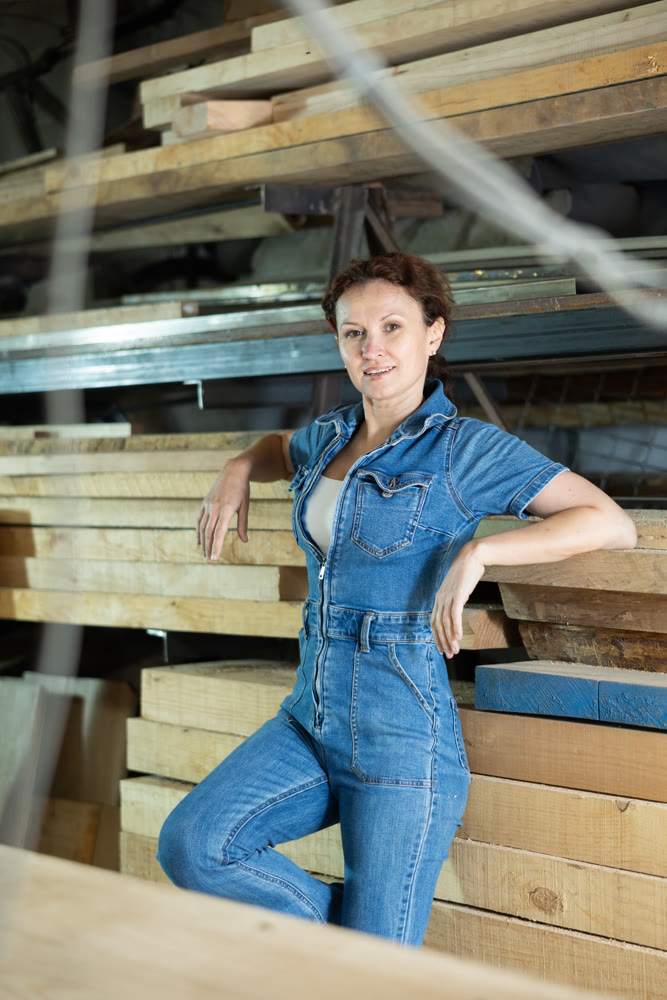 Portrait of positive female lumber warehouse worker