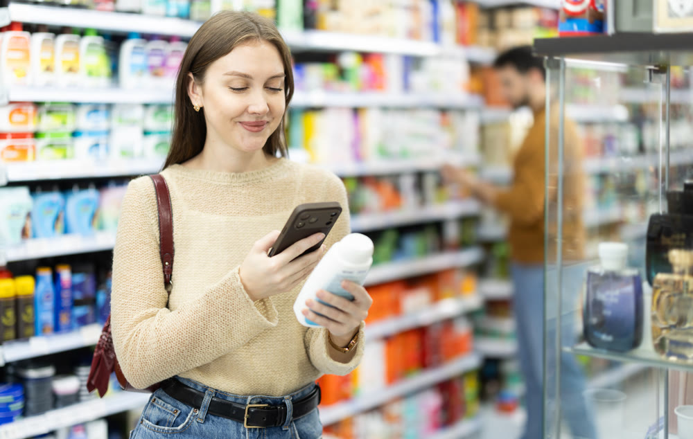 Young woman scanning QR code on care products