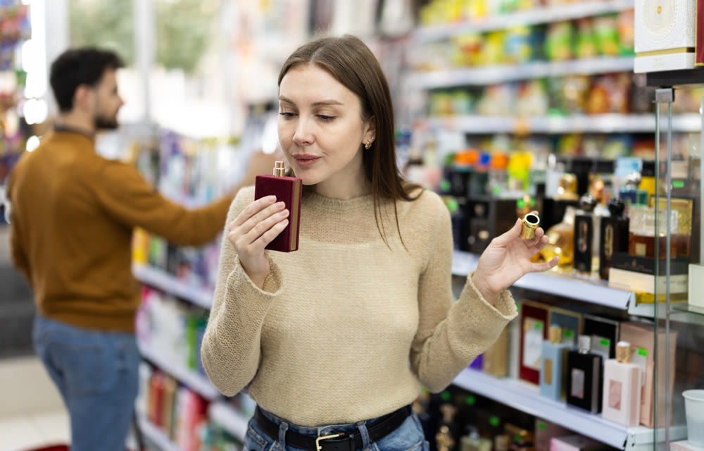 Woman customer sniffs perfume, choose spring fragrance perfume.