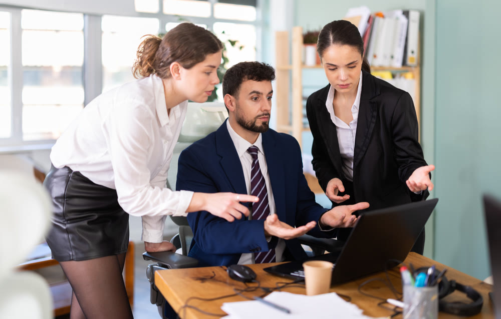 Colleagues discussing project on laptop together