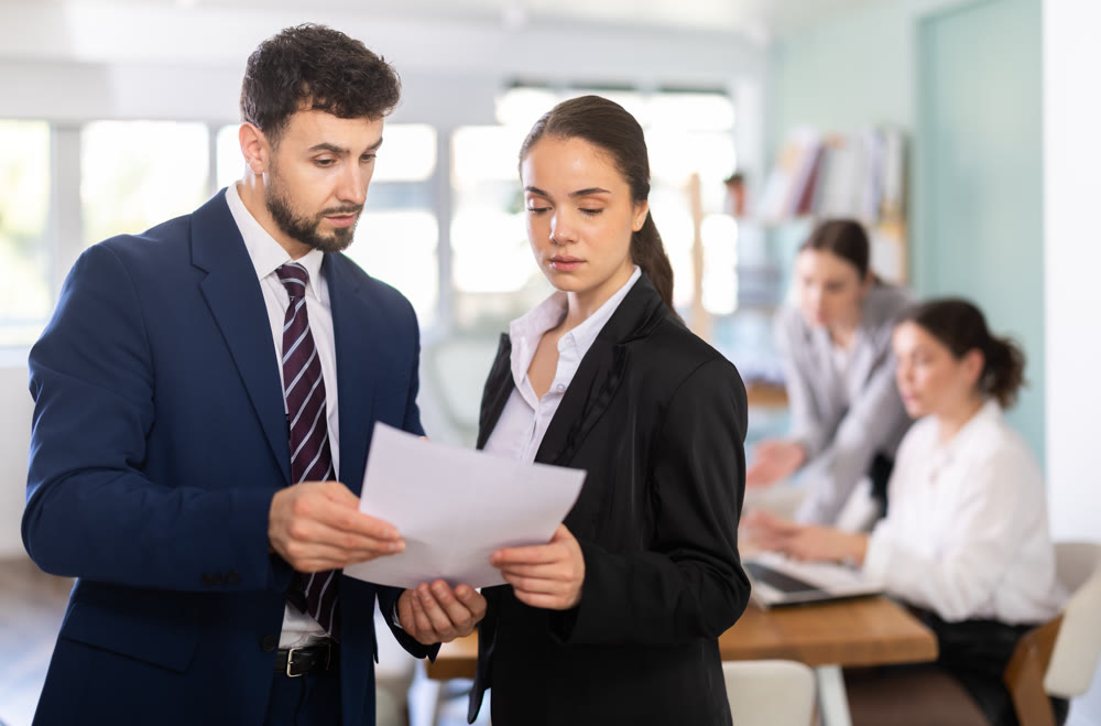 Male and female colleagues looking at document in office