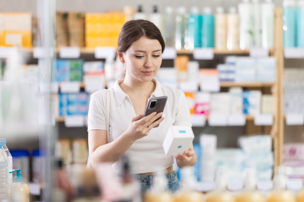 woman scans a box of pills on her phone