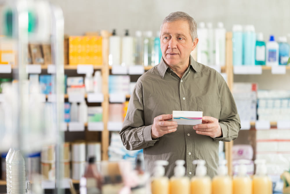 Senior man buys pills at pharmacy