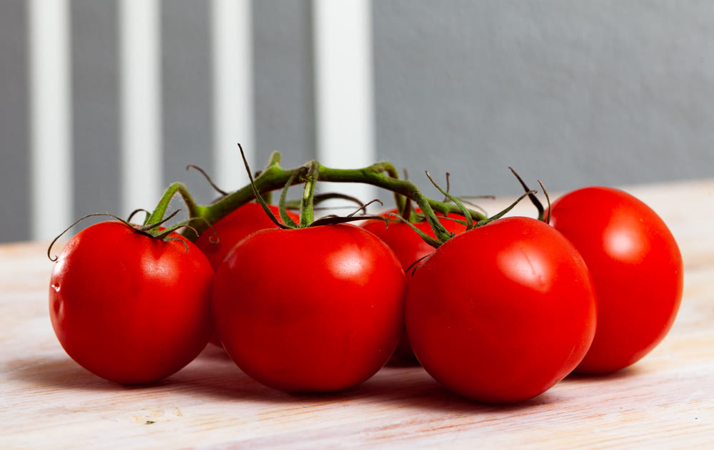 Tasty appetizing tomatoes on a wooden surface