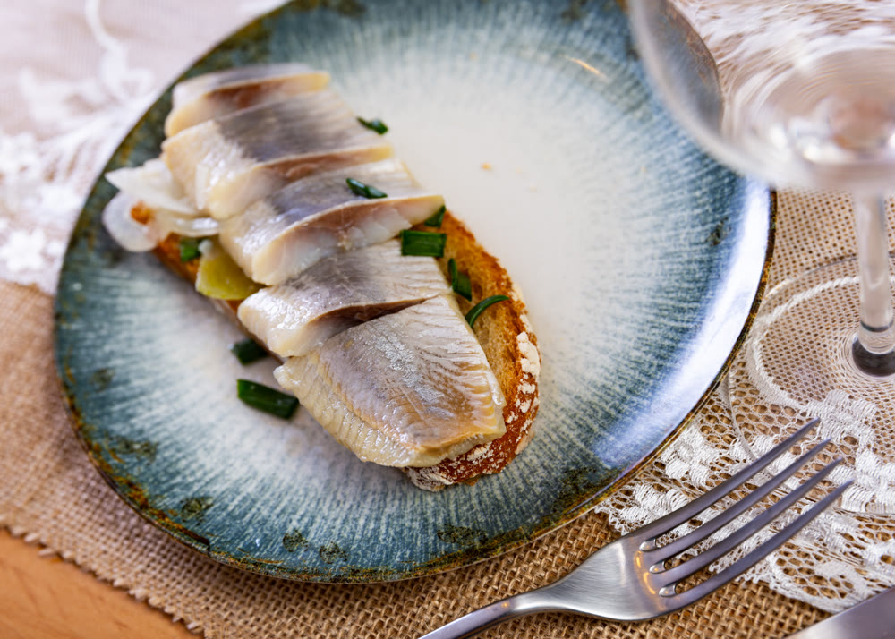 Sandwich with slices of salted herring fillet and pickled onions