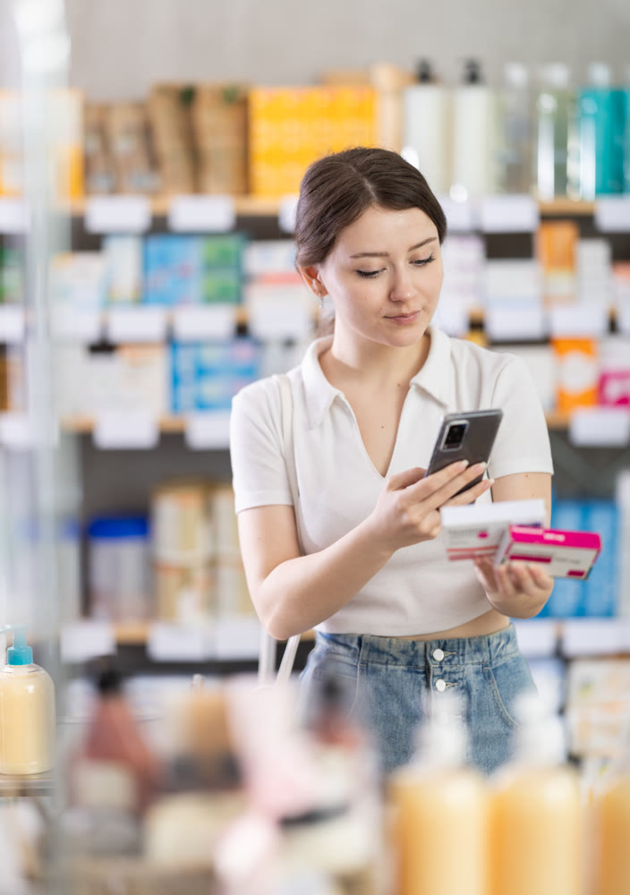 Girl scans code on package of paracetamol pills to check expiration date
