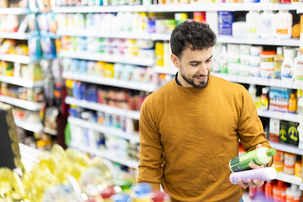 Male shopper is shopping in a supermarket, buying body care products