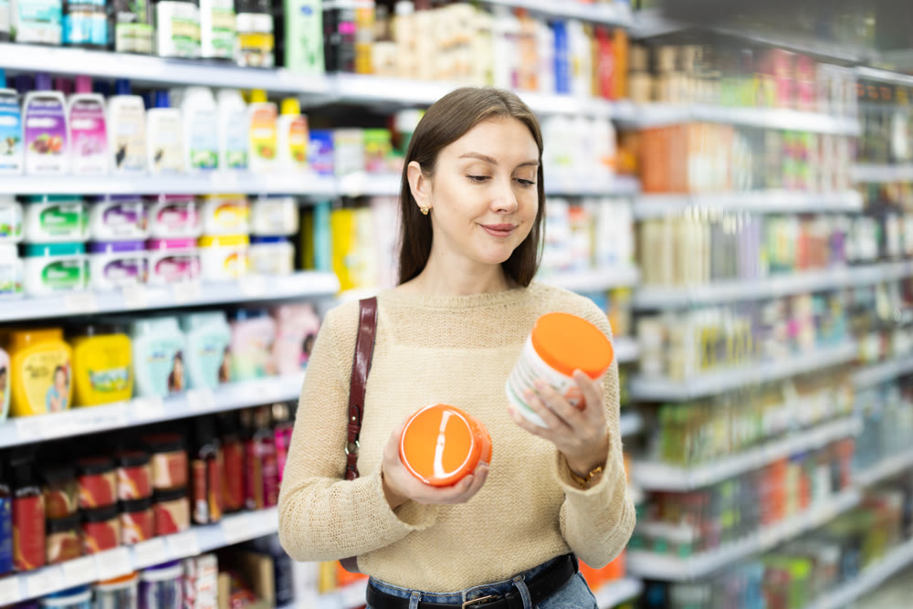 Woman spends time in store, looking for goods and select care product