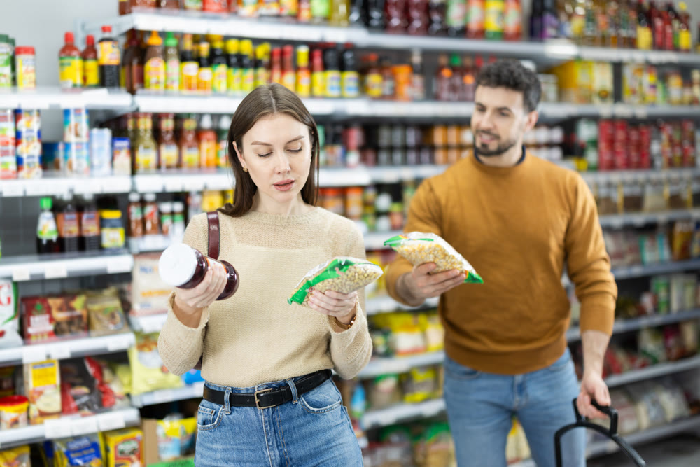 Girl customer in supermarket search and select product beans