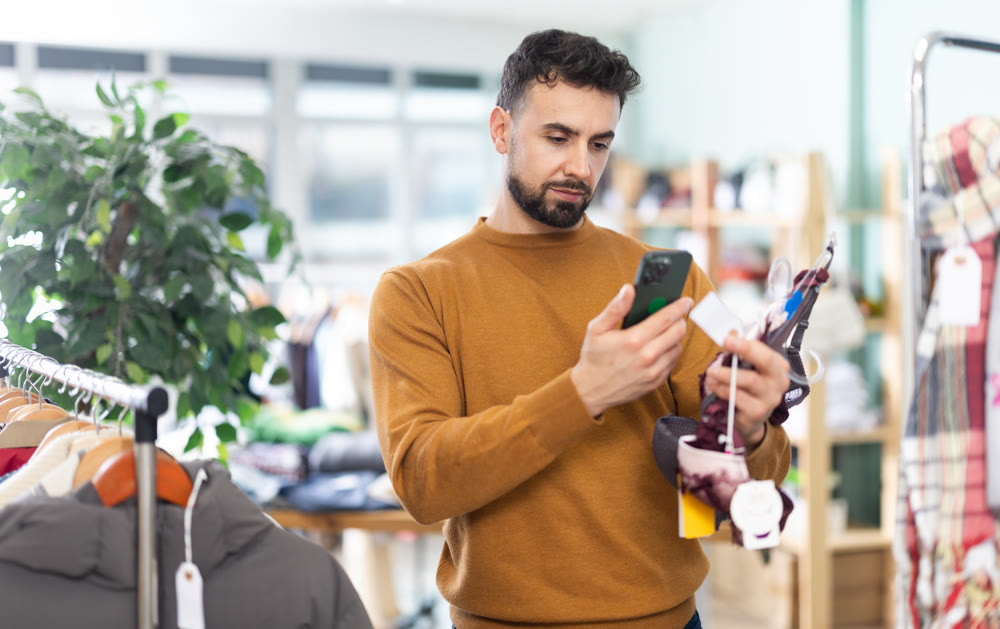 Young man scans qr code of women's lingerie in store