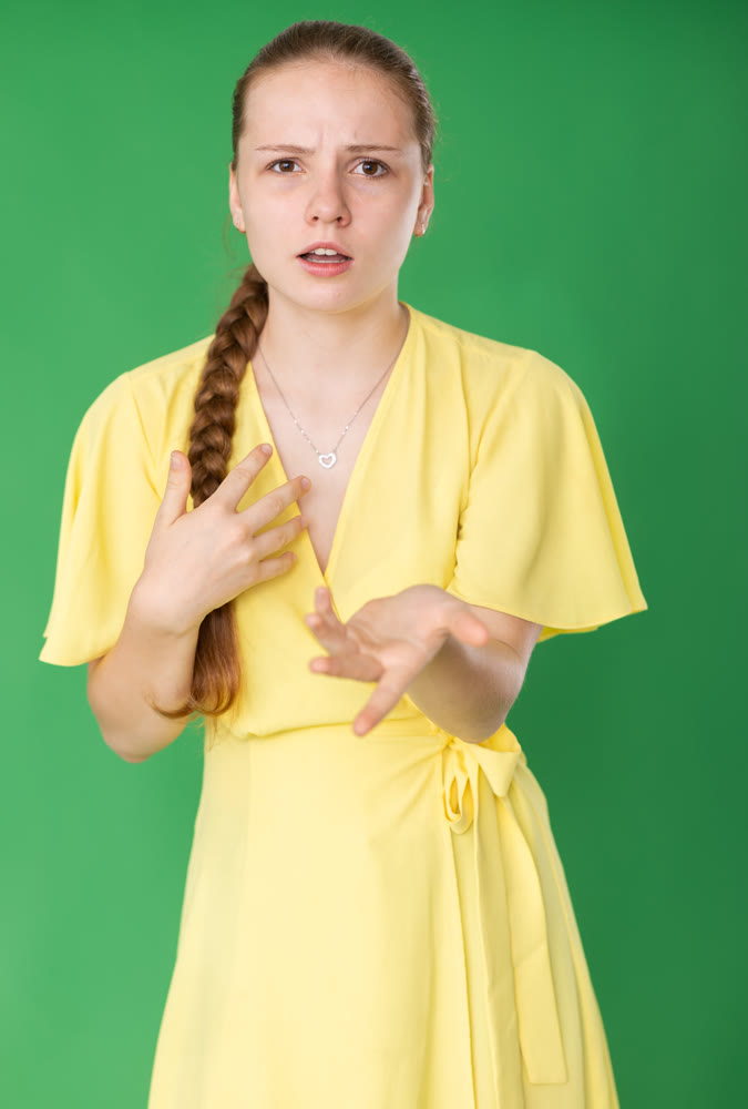 Teenage girl explaining or telling something in front of green screen