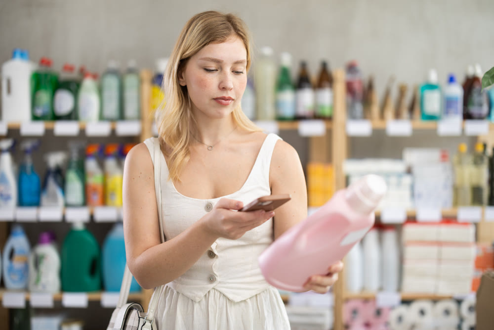 Young woman scanning qr code for detergent
