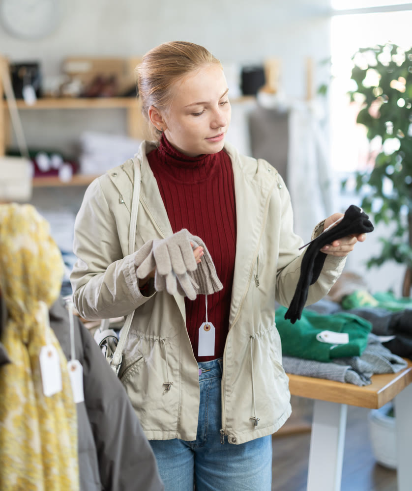 Teenage girl choosing winter gloves in clothing store