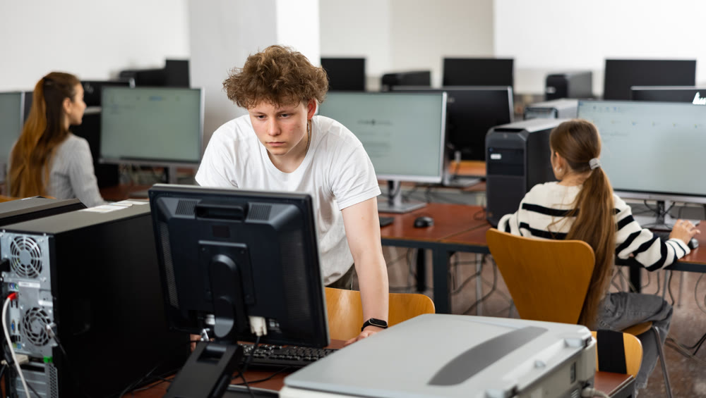 Portrait of guy working at computer in computer class at school